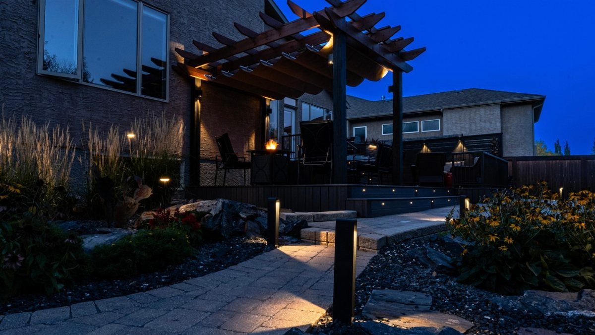 17 Backyard Deck Designs for Every Yard and Budget 3 A wooden pergola covering a dark deck with outdoor furniture during twilight.