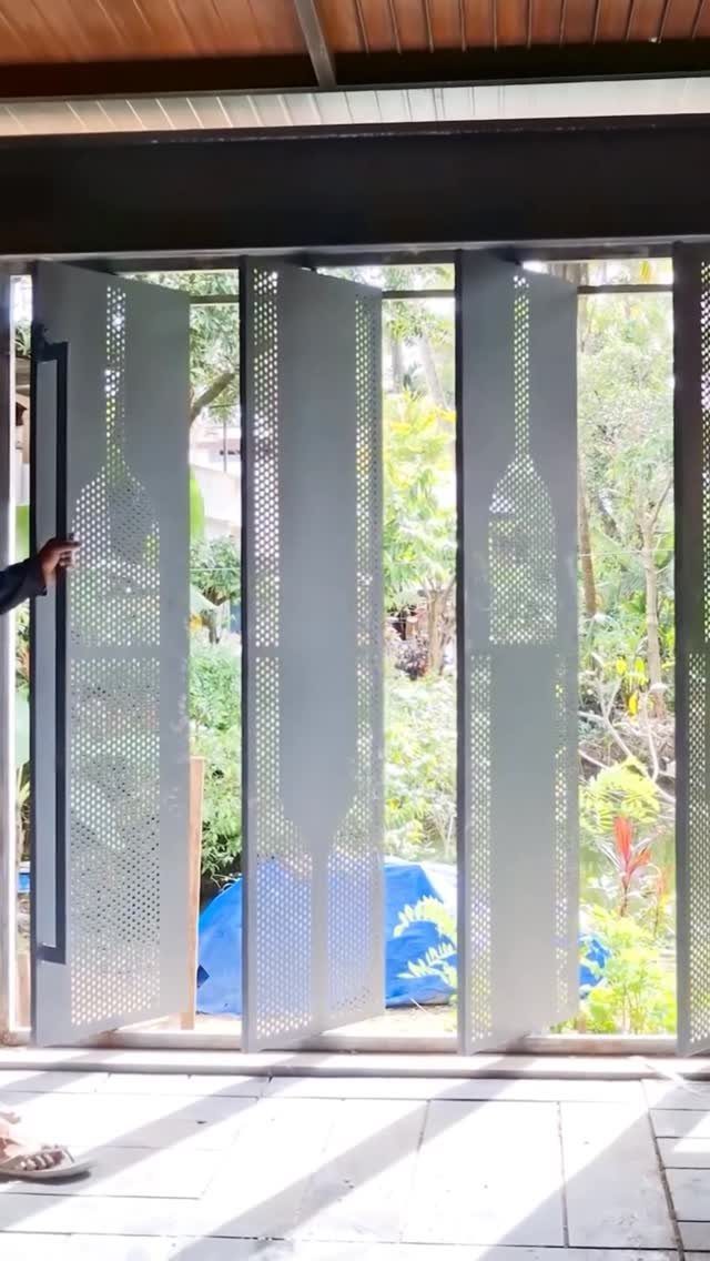 17 Backyard Deck Designs for Every Yard and Budget 12 Perforated grey metal privacy screens with bottle patterns being opened to reveal a green garden.