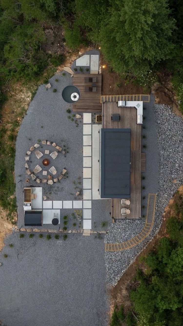 17 Backyard Deck Designs for Every Yard and Budget 4 Aerial view of a modern backyard with wooden decks, stone paths, and an outdoor kitchen.