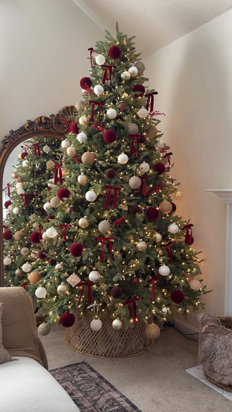 A decorated Christmas tree with white and red ornaments and warm twinkling lights in a room.