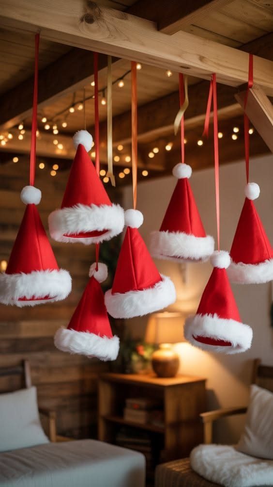 Red and white Santa hats hanging from a wooden ceiling beam by colorful ribbons.