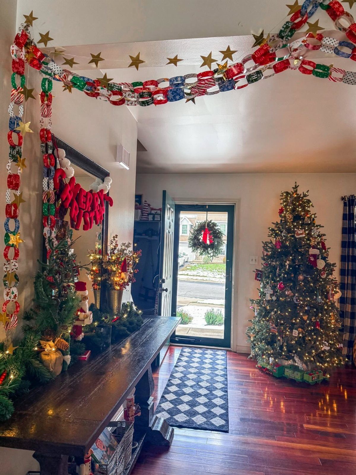 Colorful paper chains with gold stars hanging across a white ceiling in a decorated room.