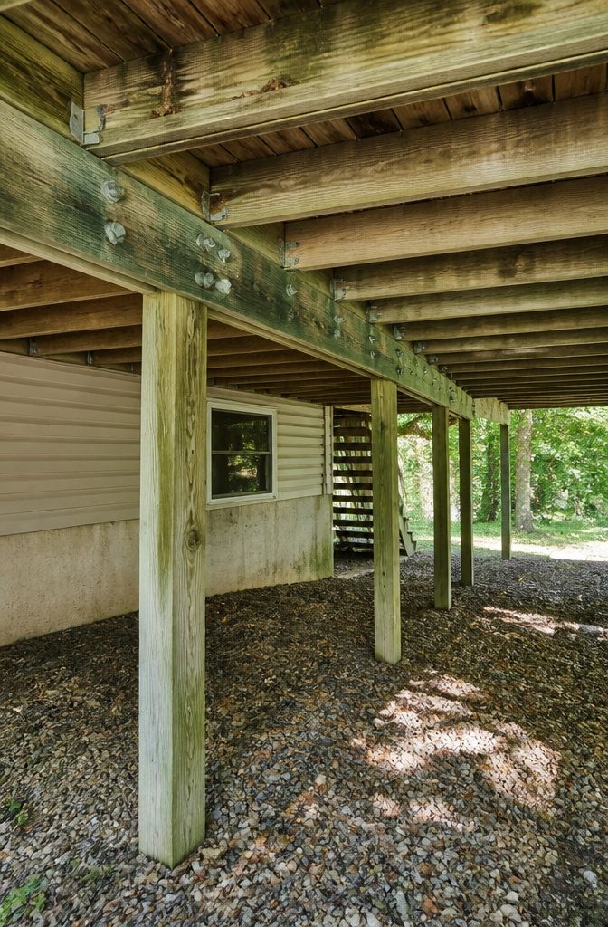 Building a Covered Deck Off the Back of a House: What the Work Actually Involves 3 A detailed view of a deck frame with wooden posts and beams.