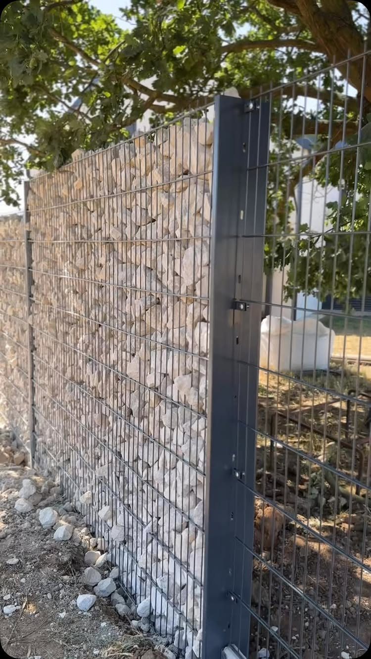 25 Creative and Gardening Ideas for Backyards Big or Small 16 A gabion wall filled with light stones held within a dark metal wire mesh frame.