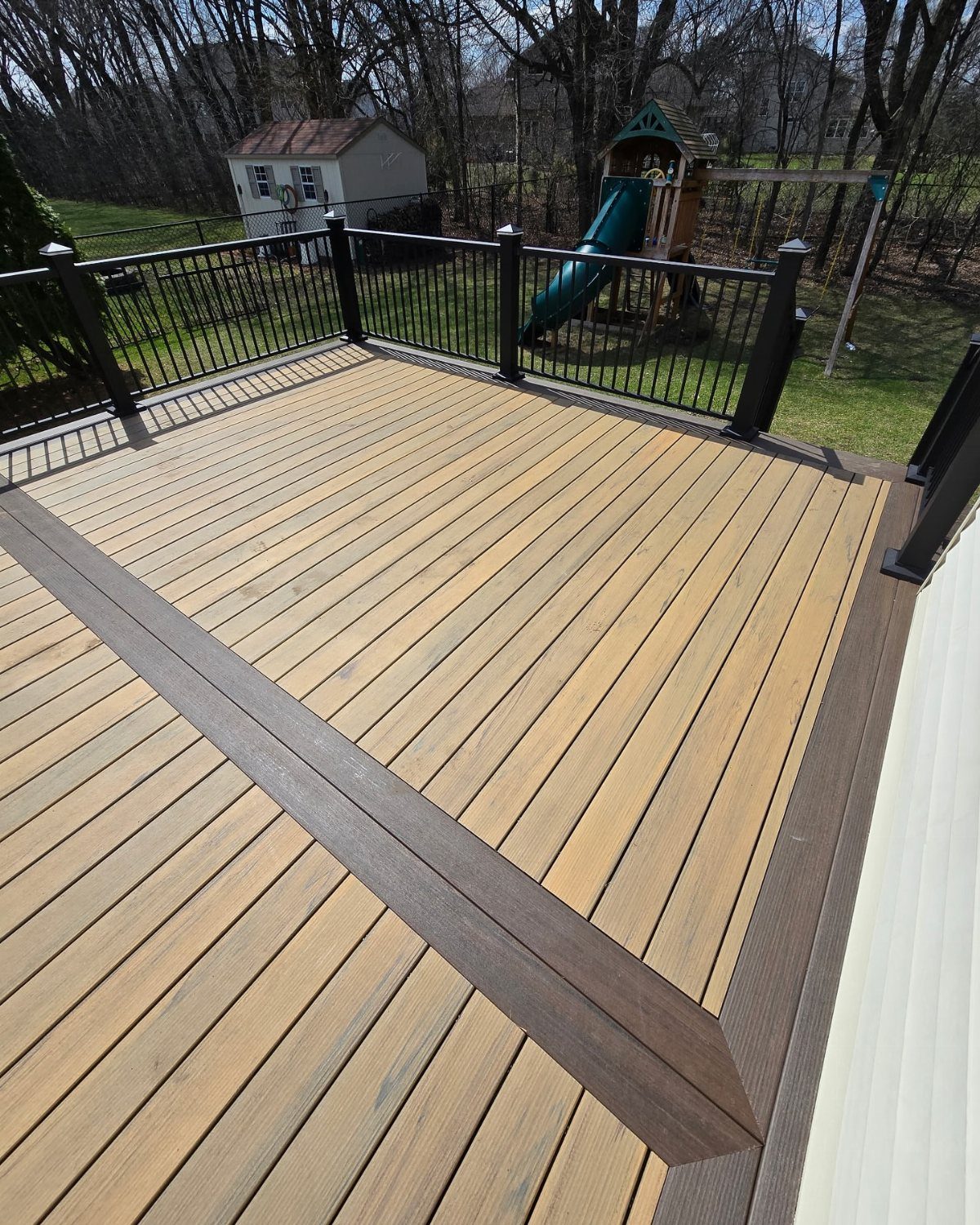 12 Deck Floor Design Ideas for Picture-Frame Borders to Patterned Layouts 1 Wooden deck with light tan planks and a dark brown picture frame border design.