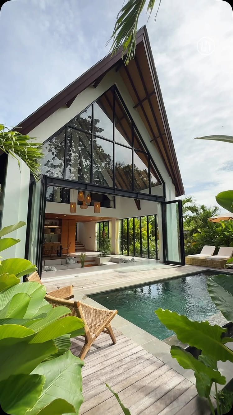 12 Deck Floor Design Ideas for Picture-Frame Borders to Patterned Layouts 5 Wooden deck boards in the foreground next to a swimming pool and tropical plants.