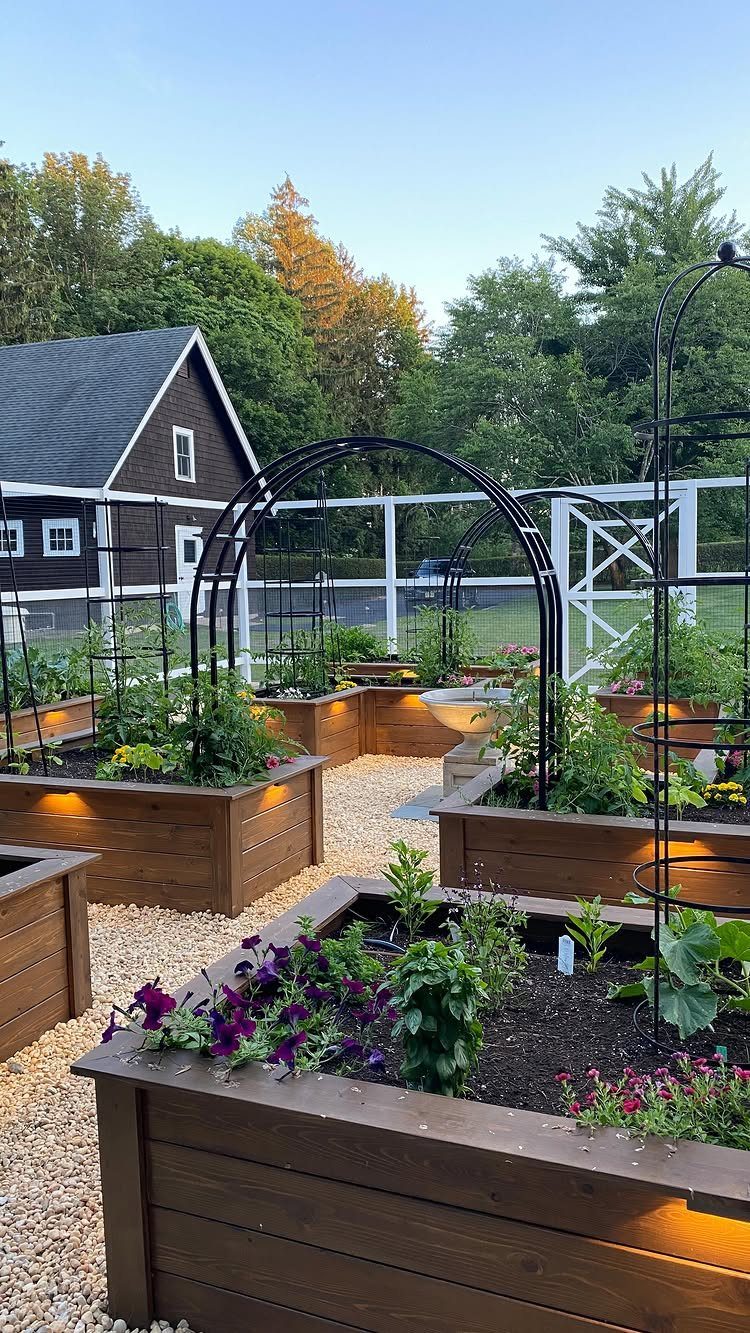 Wooden raised garden beds with decorative top caps and integrated lighting filled with various green plants.