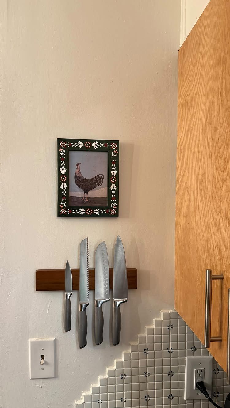 5 DIY Kitchen Ideas for Storage That Actually Fits Your Space 4 Four silver kitchen knives hanging on a wooden magnetic strip mounted on a white wall.