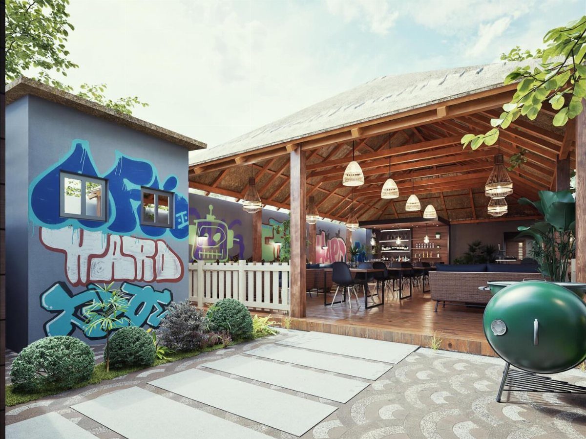A large wooden outdoor pavilion with dining tables, hanging lights, and a green grill on a patio.