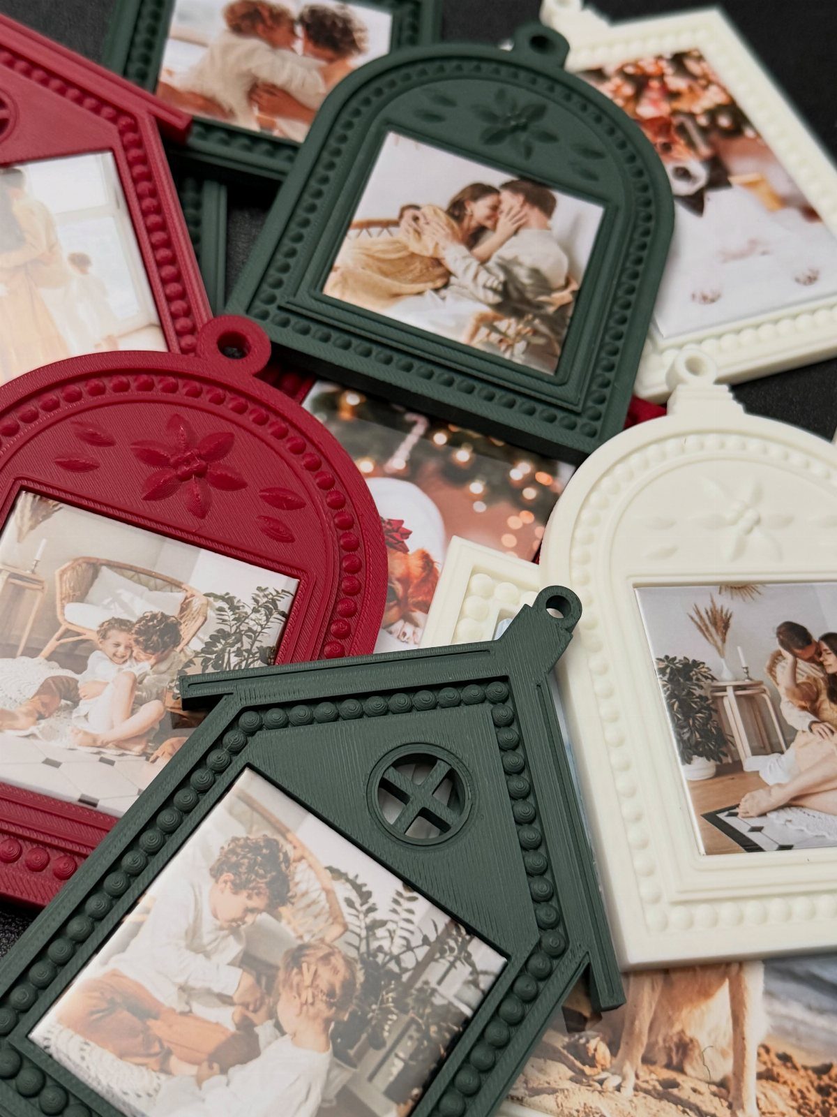 Various colorful photo ornaments with red, green, and white frames scattered on a dark surface.