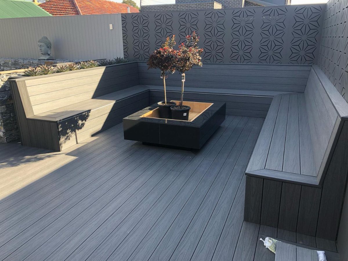 12 Porch and Deck Ideas for Outdoor Living 8 Grey composite deck with built-in U-shaped bench seating and a central square planter box.