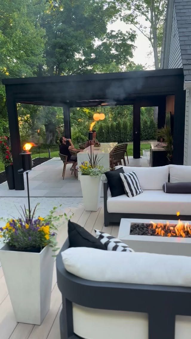 12 Porch and Deck Ideas for Outdoor Living 9 Curved white outdoor sofas surround a lit rectangular fire pit on a modern wooden deck.