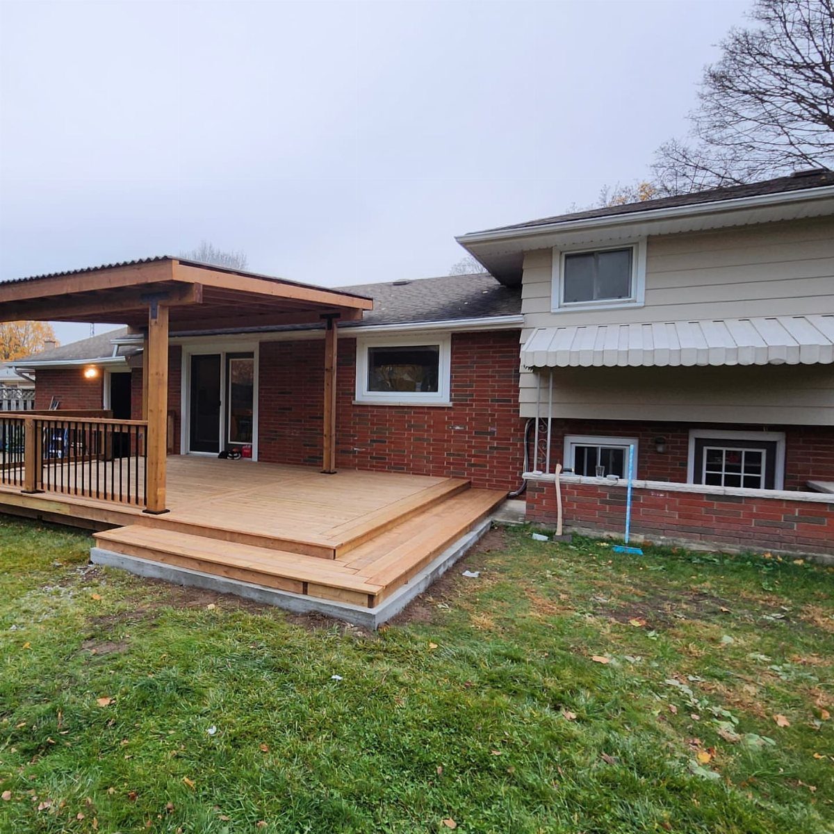 12 Porch and Deck Ideas for Outdoor Living 10 A new wooden deck with a large protective roof overhang attached to a brick house.