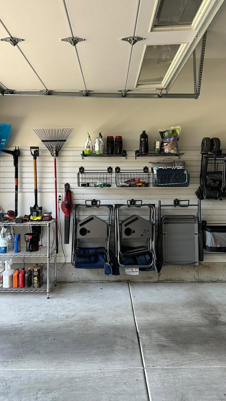 6 Small Garage Building Ideas for Storage, Projects & Living Space 2 Garage wall with slatwall organization, black shelves, metal baskets, and various cleaning tools.